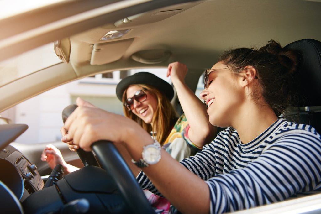 Two friends enjoying music in the car