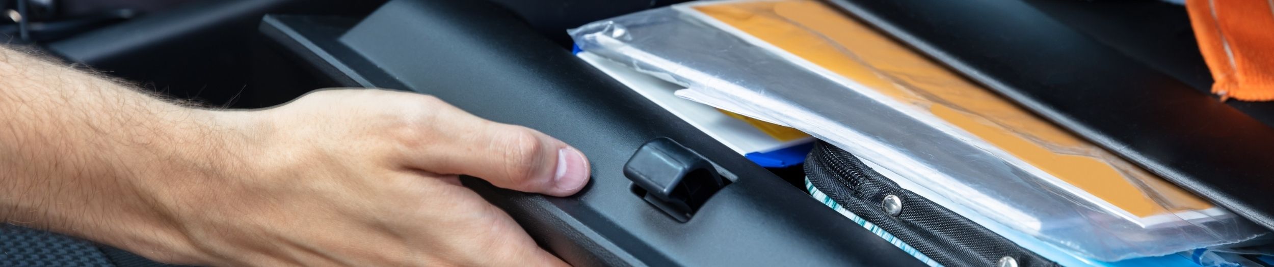 Person opening glove compartment of car