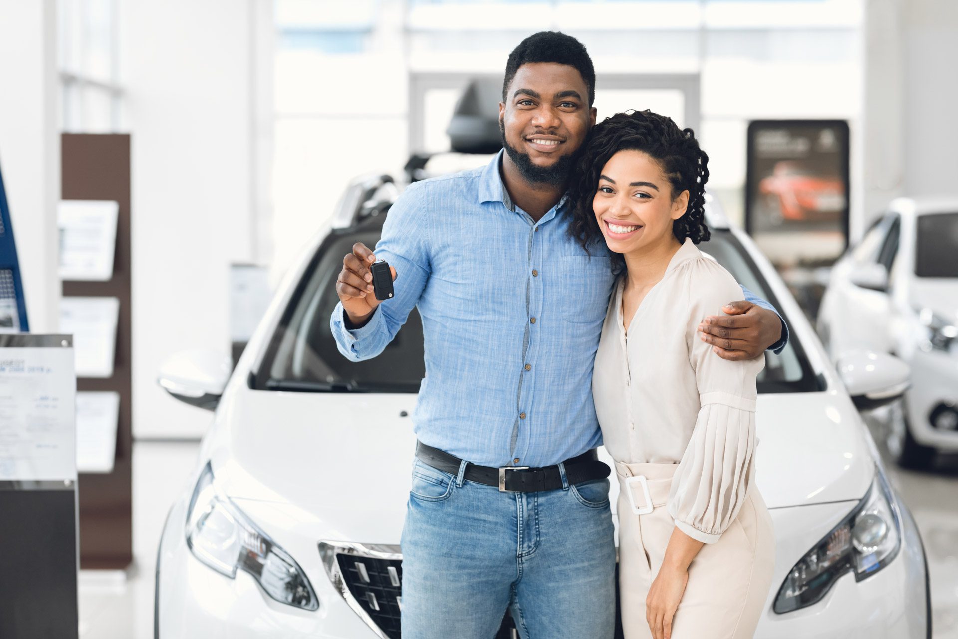 couple buying a car holding keys