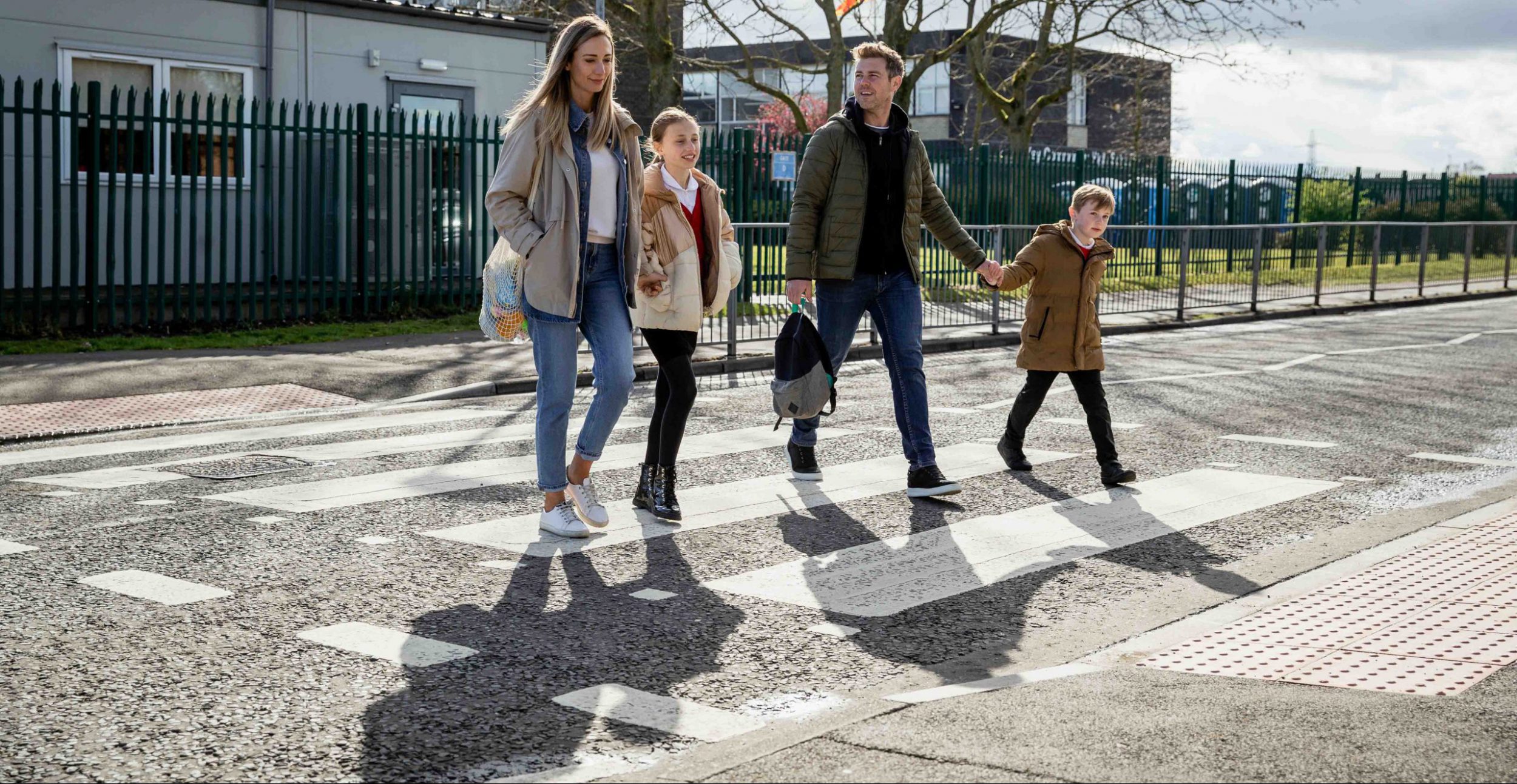 Family crossing the road safely at a zebra crossing