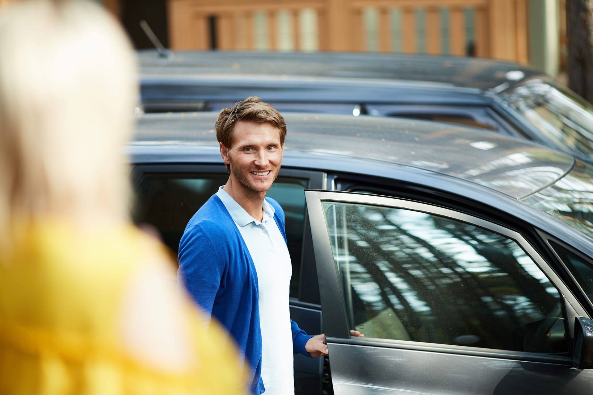 a young man entering a car whilst the seller watches